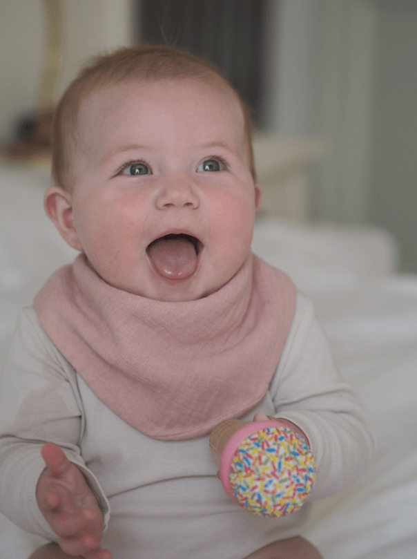 Girl model wearing Dusty Pink dribble bib whilst holding ice cream