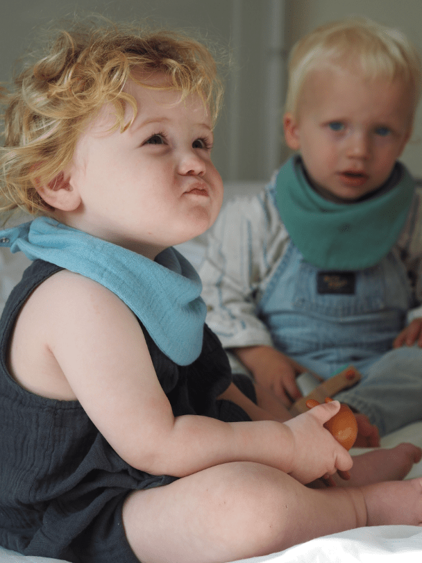 2 boy models wearing Sage and Light Blue dribble bibs